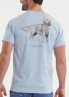 Man wearing a light blue t-shirt with a graphic of a dog and text on the back, on a plain background.