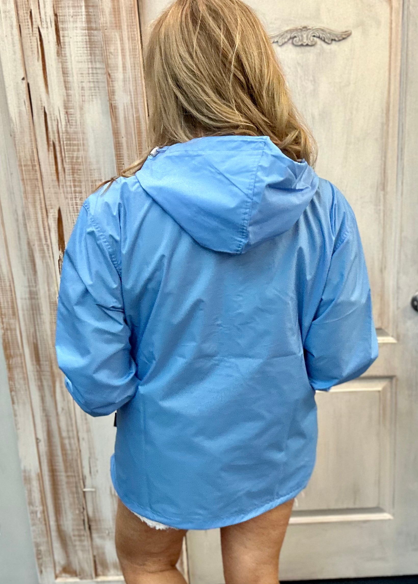 Kim wearing our new Charles River Unlined Pullover Rain Jacket, Standing in front our a dressing room. Back View with hood.