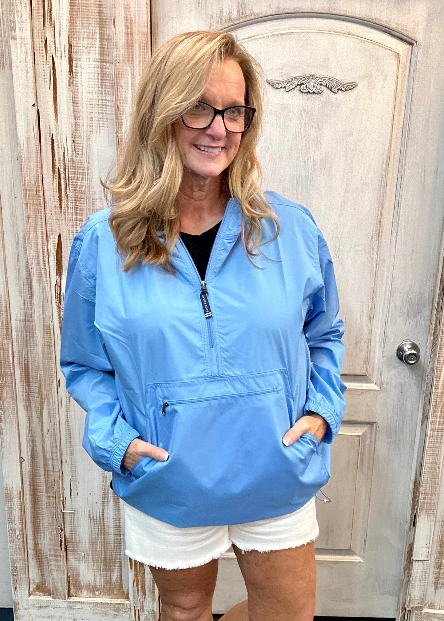 Kim wearing our new Charles River Unlined Pullover Rain Jacket, Standing in front our a dressing room. Front View.
