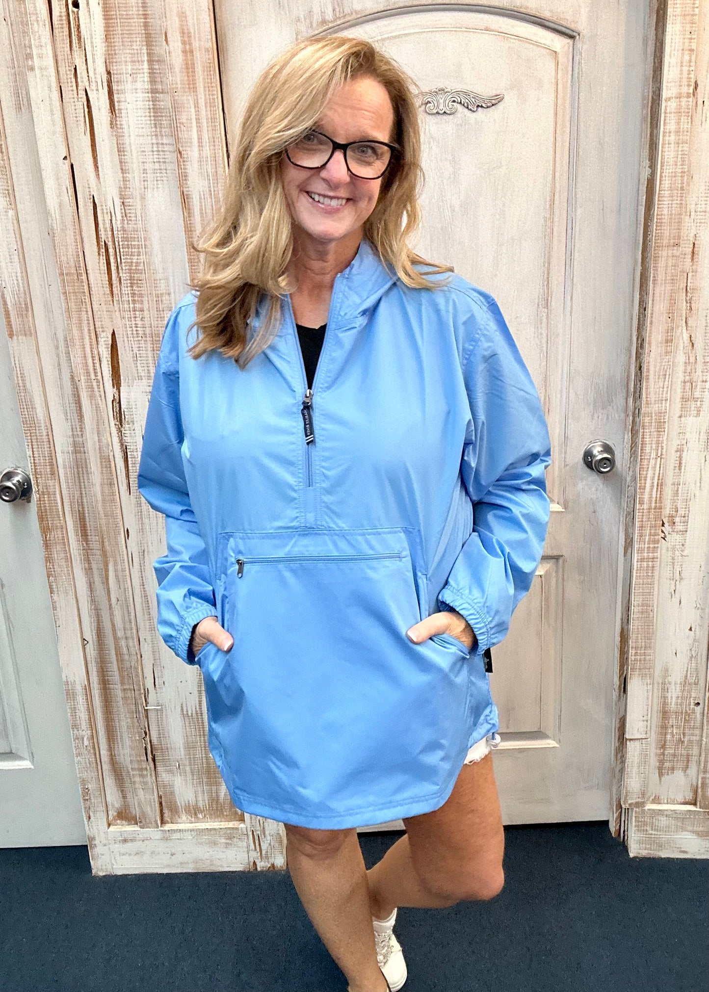 Kim wearing our new Charles River Unlined Pullover Rain Jacket, Standing in front our a dressing room. Front View.