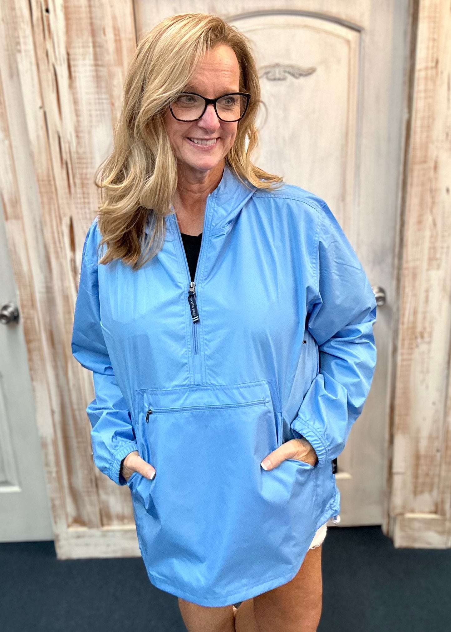 Kim wearing our new Charles River Unlined Pullover Rain Jacket, Standing in front our a dressing room. Front View.