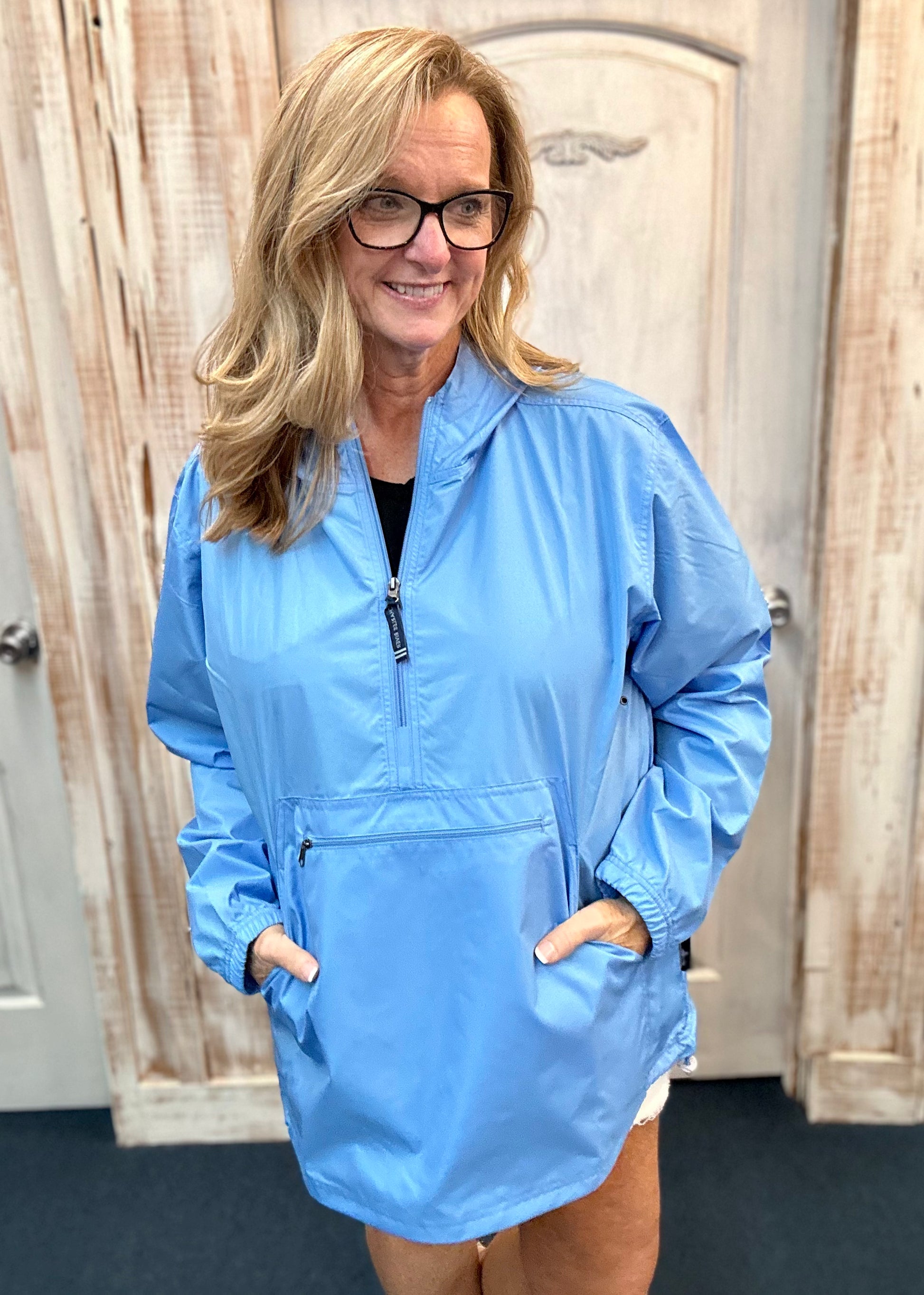 Kim wearing our new Charles River Unlined Pullover Rain Jacket, Standing in front our a dressing room. Front View.